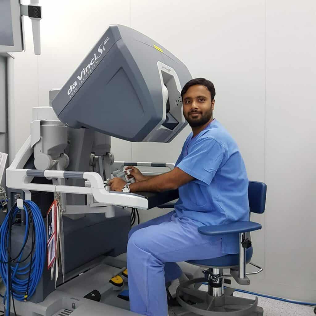 Surgeon operating Da Vinci surgical system in a hospital setting.